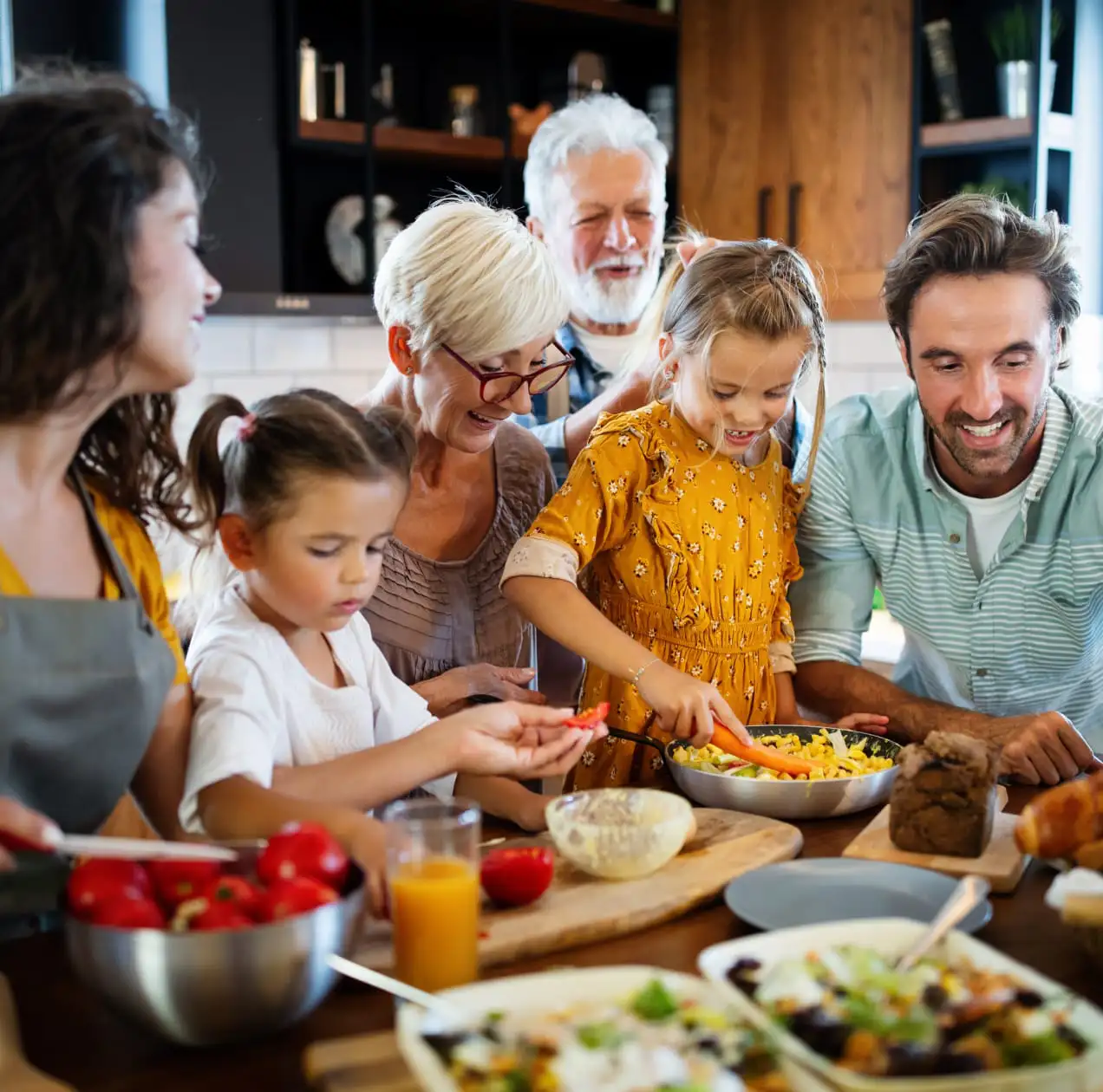 Kinder kochen mit Eltern und Großeltern zusammen